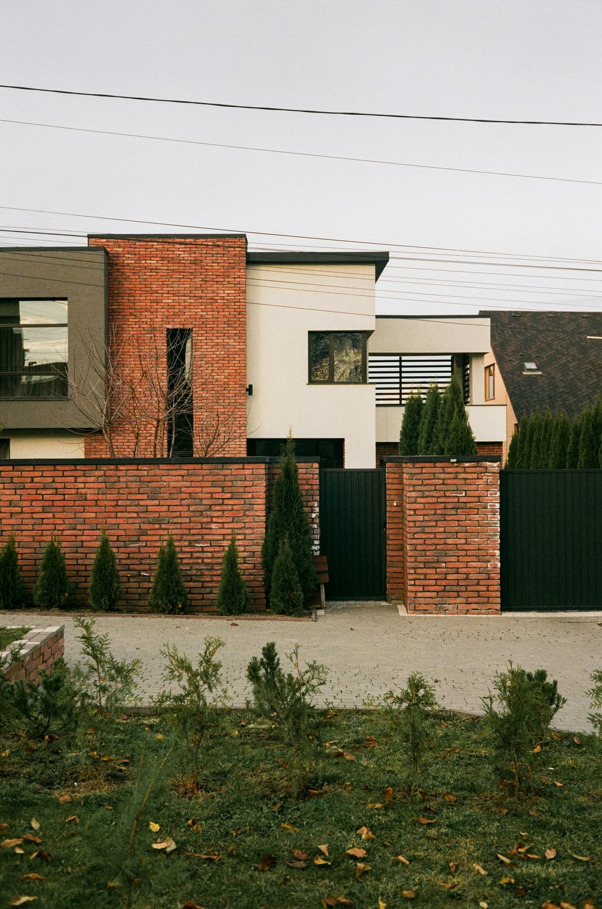 Modern house with painted white render above a red brick wall