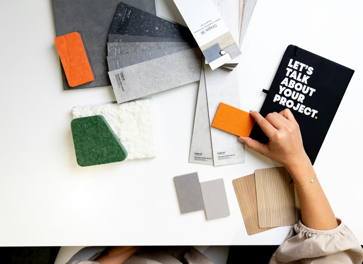 Hand choosing between paint and material swatches for a Mickleover decorating project